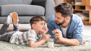 Little boy and father with savings for education at home