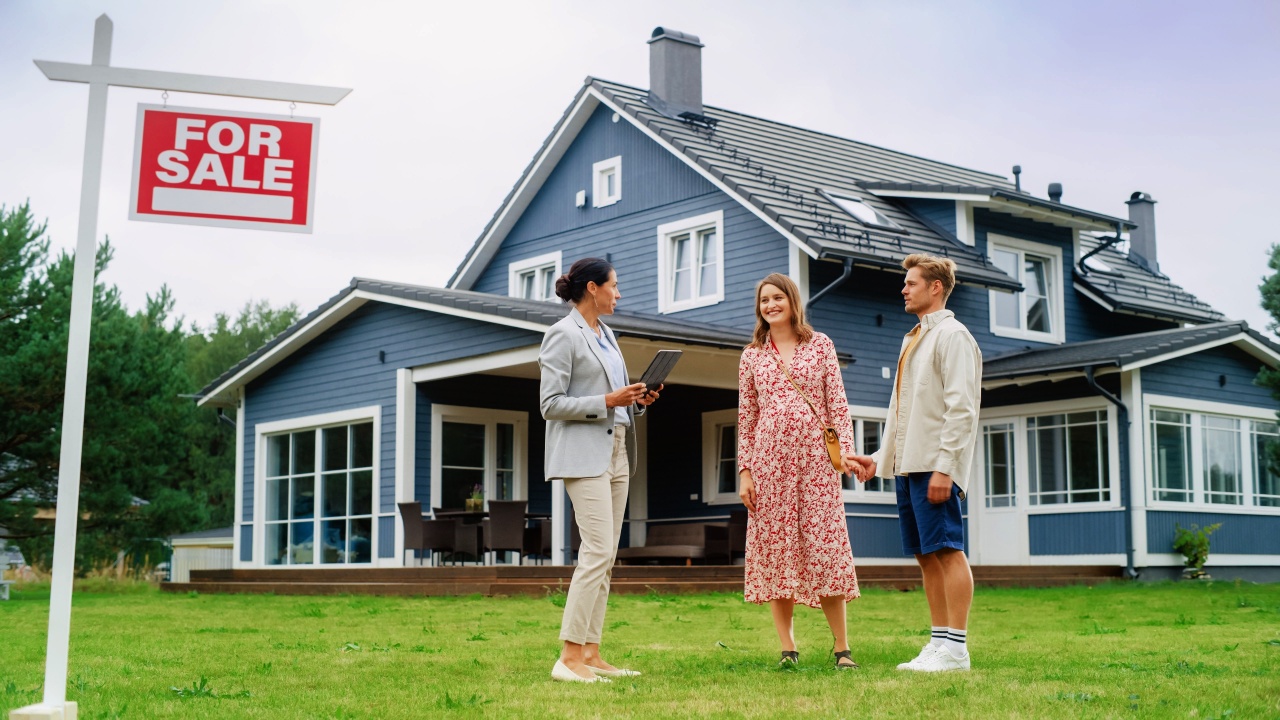 Realtor shows large residential property to young couple