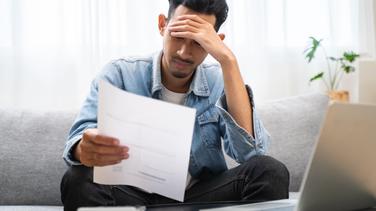 Stressed Young Asian adults are looking at credit card bills issued documents