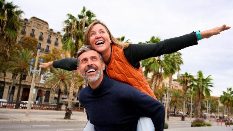 Middle-aged Caucasian couple happy piggybacking around tourist attractions