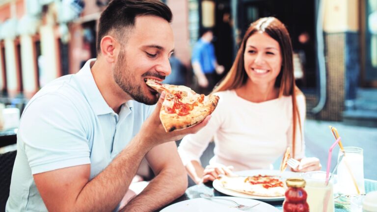 couple enjoying pizza outside