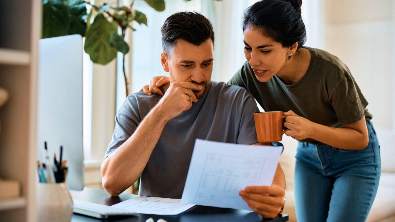 man and his wife going through bills while planning their home finances at home