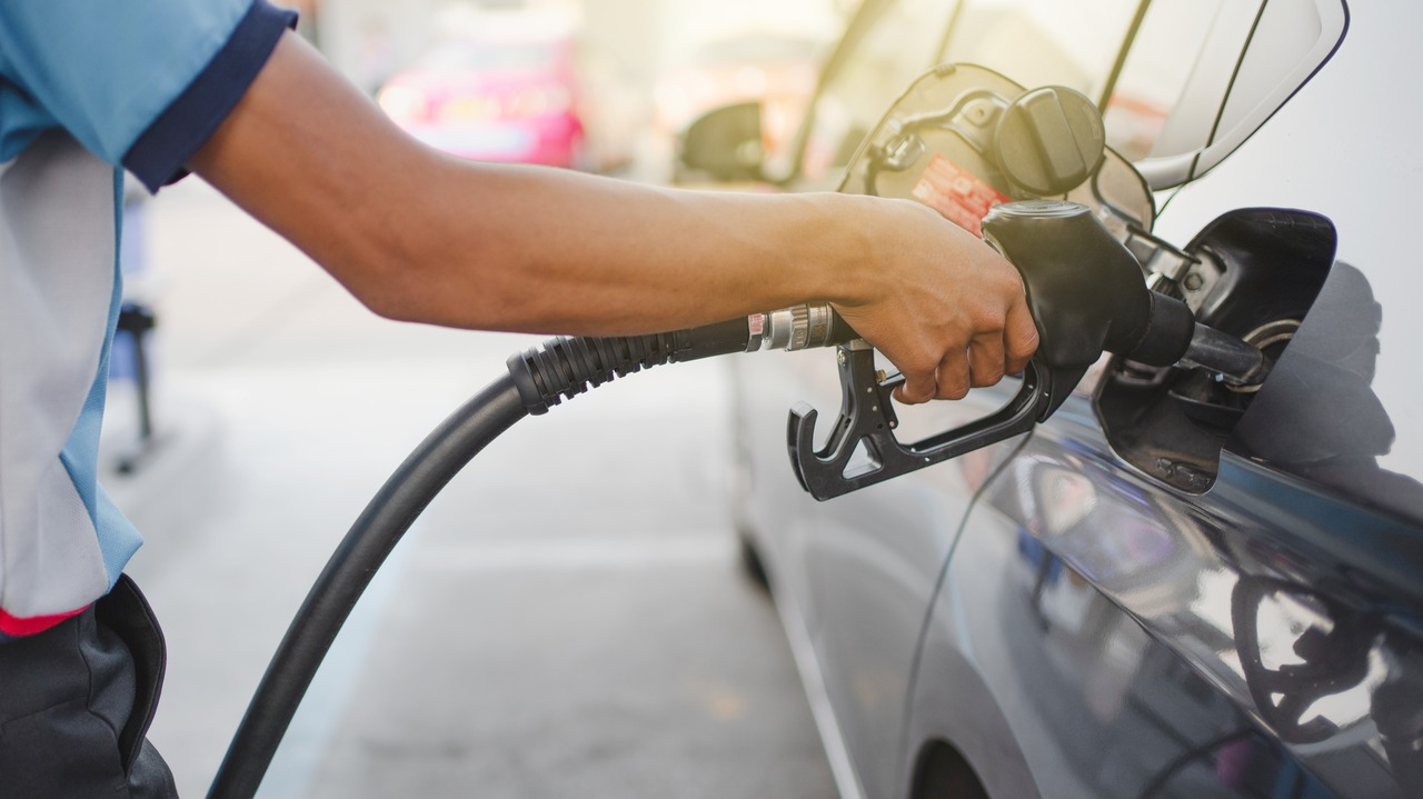 Hand of attendant holding refueling car and pumping at a gas petrol Station