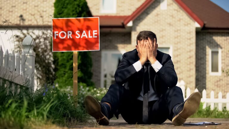 Extremely upset real estate manager sitting by for sale signboard, failed deal