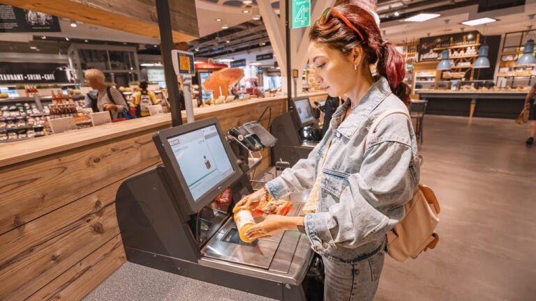 woman using self checkout at grocery store