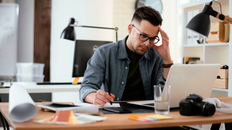 Young stressed handsome businessman working in office