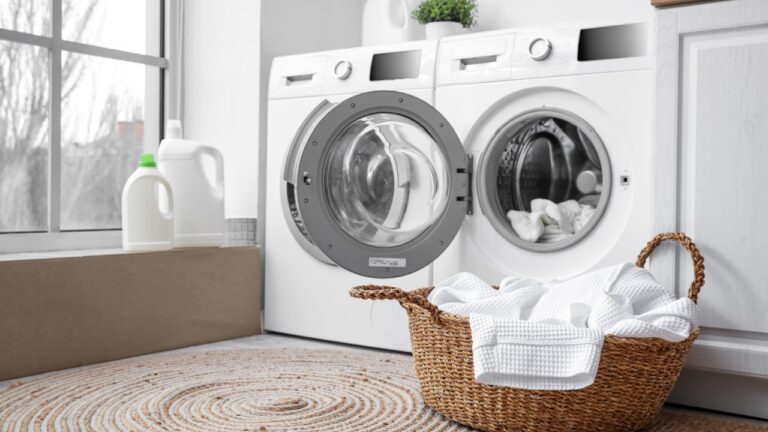 Modern washing machines with dirty clothes in laundry room