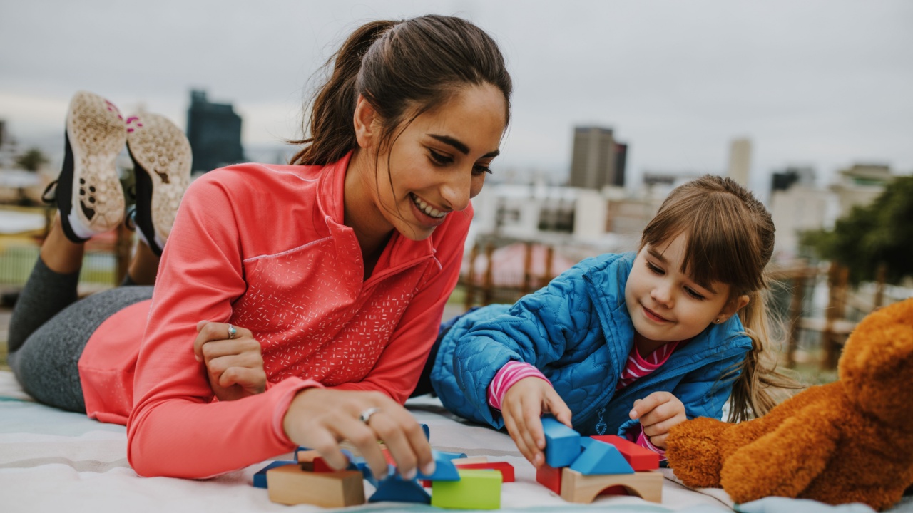 Woman playing with a small girl at the park.